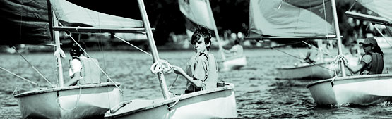 Teens sail small boats.